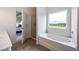 Bright bathroom featuring a soaking tub with a view and an open doorway to the bedroom at 437 Autrey Dr, Douglasville, GA 30134