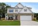 Charming two-story home featuring a stone-accented facade, a two-car garage, and a well-manicured lawn at 437 Autrey Dr, Douglasville, GA 30134