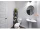 Simple half-bathroom features a pedestal sink and decorative wall shelves at 437 Autrey Dr, Douglasville, GA 30134