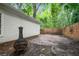 Secluded backyard with brick patio, wood fence, and mature trees at 4594 Poplar Rd, Pine Lake, GA 30072