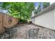 Serene brick patio with seating, surrounded by a wooden fence and lush greenery offering a relaxing outdoor space at 4594 Poplar Rd, Pine Lake, GA 30072