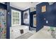 Cozy bathroom boasts a jacuzzi tub, neutral tiling and dark blue walls at 4594 Poplar Rd, Pine Lake, GA 30072