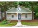 Charming bungalow features a quaint front porch, fresh paint, and mature trees at 4594 Poplar Rd, Pine Lake, GA 30072