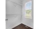 Walk-in closet with white wire shelving, a window, and hardwood flooring for organized storage at 7025 Bavarian Wood Pl, Buford, GA 30518