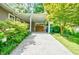 Carport attached to home, featuring lush green landscaping, storage area, and concrete driveway at 3027 Vista Brook Dr, Decatur, GA 30033