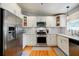 Modern kitchen boasts stainless steel appliances, white cabinets, light countertops, and hardwood floors at 3027 Vista Brook Dr, Decatur, GA 30033