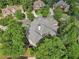 Overhead view of a large home with a striking roofline, surrounded by lush trees and well-maintained landscaping at 3099 Hidden Falls Dr, Buford, GA 30519