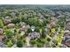 Aerial view showcases a large luxury home nestled in a lush, green neighborhood with mature trees and well-manicured lawns at 3099 Hidden Falls Dr, Buford, GA 30519