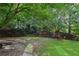 Sprawling backyard, featuring a combination of manicured lawn, mature trees, and a privacy fence at 3099 Hidden Falls Dr, Buford, GA 30519