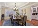 Traditional dining room with chandelier, rug, and adjacent bar area at 3099 Hidden Falls Dr, Buford, GA 30519