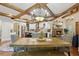 Open dining area with a large wooden table, wood ceiling beams, chandelier, and access to living areas at 3099 Hidden Falls Dr, Buford, GA 30519
