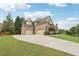 Spacious driveway leading to a three-car garage on this beautiful brick home with well-manicured lawn at 3099 Hidden Falls Dr, Buford, GA 30519