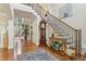 Elegant foyer with hardwood floors, staircase with iron railing, and decorative accents, creating a grand entrance at 3099 Hidden Falls Dr, Buford, GA 30519