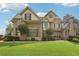 Charming two-story home with manicured lawn, brick and stone exterior, and professionally landscaped front yard at 3099 Hidden Falls Dr, Buford, GA 30519