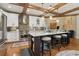 Kitchen with custom cabinets, large island with seating, stainless steel appliances, and wooden beam ceiling at 3099 Hidden Falls Dr, Buford, GA 30519