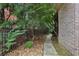 Landscaped walkway featuring mature trees and shrubbery, leading to the brick home's entrance at 3099 Hidden Falls Dr, Buford, GA 30519