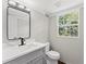 Modern bathroom featuring a sleek vanity, updated fixtures, and a window with a view of the outdoors at 5254 Greenpoint Drive, Stone Mountain, GA 30088