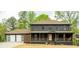 Charming two-story home featuring a front porch, two-car garage, neutral paint, and mature trees at 5254 Greenpoint Drive, Stone Mountain, GA 30088
