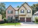Charming two-story home featuring a brick facade, green shutters, and a well-manicured lawn at 5688 Baffin Rd, Atlanta, GA 30349