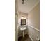 Cozy half bathroom features a pedestal sink, dark wood mirror, and tiled floors at 5688 Baffin Rd, Atlanta, GA 30349