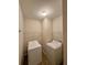 Bright laundry room features a washer and dryer and wire shelving for storage at 5688 Baffin Rd, Atlanta, GA 30349