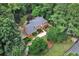 An aerial view of a red brick house featuring a driveway, lush landscaping, and mature trees surrounding the property at 1320 Northcliff Trce, Roswell, GA 30076