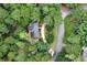 A high-angle view displays a well-maintained property surrounded by mature trees, a winding driveway, and a manicured lawn at 1320 Northcliff Trce, Roswell, GA 30076