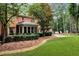 Landscaped backyard with a stone pathway, lush green lawn, mature trees, and an enclosed sunroom at 1320 Northcliff Trce, Roswell, GA 30076