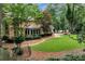 Spacious backyard featuring a manicured lawn, stone pathway, mature trees, and an enclosed sunroom at 1320 Northcliff Trce, Roswell, GA 30076