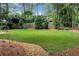 Spacious, well-maintained backyard with green lawn and a border of trees behind a wooden fence at 1320 Northcliff Trce, Roswell, GA 30076