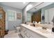 Well-lit bathroom with double vanity, framed mirror, and separate toilet at 1320 Northcliff Trce, Roswell, GA 30076