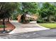 A wide driveway leads to a brick house, complemented by manicured landscaping and mature trees at 1320 Northcliff Trce, Roswell, GA 30076