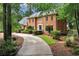 Lovely brick home showcasing a well-maintained lawn, mature trees, and a winding driveway for added curb appeal at 1320 Northcliff Trce, Roswell, GA 30076
