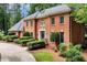 Brick home showcasing a well-maintained lawn, manicured bushes, and a winding driveway at 1320 Northcliff Trce, Roswell, GA 30076