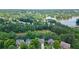Aerial view of homes by a lake surrounded by lush trees, showcasing a picturesque neighborhood at 1775 Porterton Way, Cumming, GA 30041