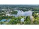 Aerial view of the neighborhood featuring tennis courts, a community pool, clubhouse, lake, and lush greenery at 1775 Porterton Way, Cumming, GA 30041