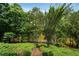 Wooded backyard with path down to a pond, offering natural beauty and tranquility at 1775 Porterton Way, Cumming, GA 30041