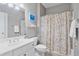 Bathroom featuring a toilet, vanity, and shower with patterned shower curtain at 1775 Porterton Way, Cumming, GA 30041