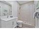 Modern bathroom featuring a tiled walk-in shower with pebble floor, updated vanity, and sleek fixtures at 1775 Porterton Way, Cumming, GA 30041