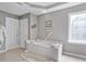 Bright bathroom with large tub, stained glass window, and walk-in closet at 1775 Porterton Way, Cumming, GA 30041