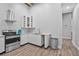 Well-lit kitchen features stainless steel appliances, white cabinetry, granite countertops, and tile flooring at 1775 Porterton Way, Cumming, GA 30041