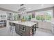 Open-concept kitchen features an island with seating and views of the living room and outdoor living area at 1775 Porterton Way, Cumming, GA 30041