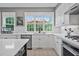 Modern kitchen featuring white cabinets, stainless steel appliances, light countertops, and a view to the patio at 1775 Porterton Way, Cumming, GA 30041
