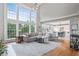 Bright living room featuring two-story windows, a large couch, and an open view to a modern kitchen at 1775 Porterton Way, Cumming, GA 30041