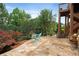 Outdoor stone patio with furniture, landscaping, and access to the upper deck for relaxing and entertaining at 1775 Porterton Way, Cumming, GA 30041