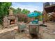 Stone patio featuring an outdoor fireplace, seating area, and string lights for relaxed outdoor living at 1775 Porterton Way, Cumming, GA 30041