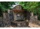Stone water feature with lion's head spouting water into a stone basin surrounded by greenery at 1775 Porterton Way, Cumming, GA 30041