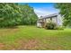 Lush backyard view with a white house, wooden deck, and green lawn under a blue sky at 33 Moriah Ne Way, Rydal, GA 30171
