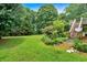 Expansive backyard features lush greenery, a wooden deck with stairs, and mature trees at 33 Moriah Ne Way, Rydal, GA 30171