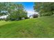 Grassy front yard on a hillside with trees, leading up to a white house at 33 Moriah Ne Way, Rydal, GA 30171